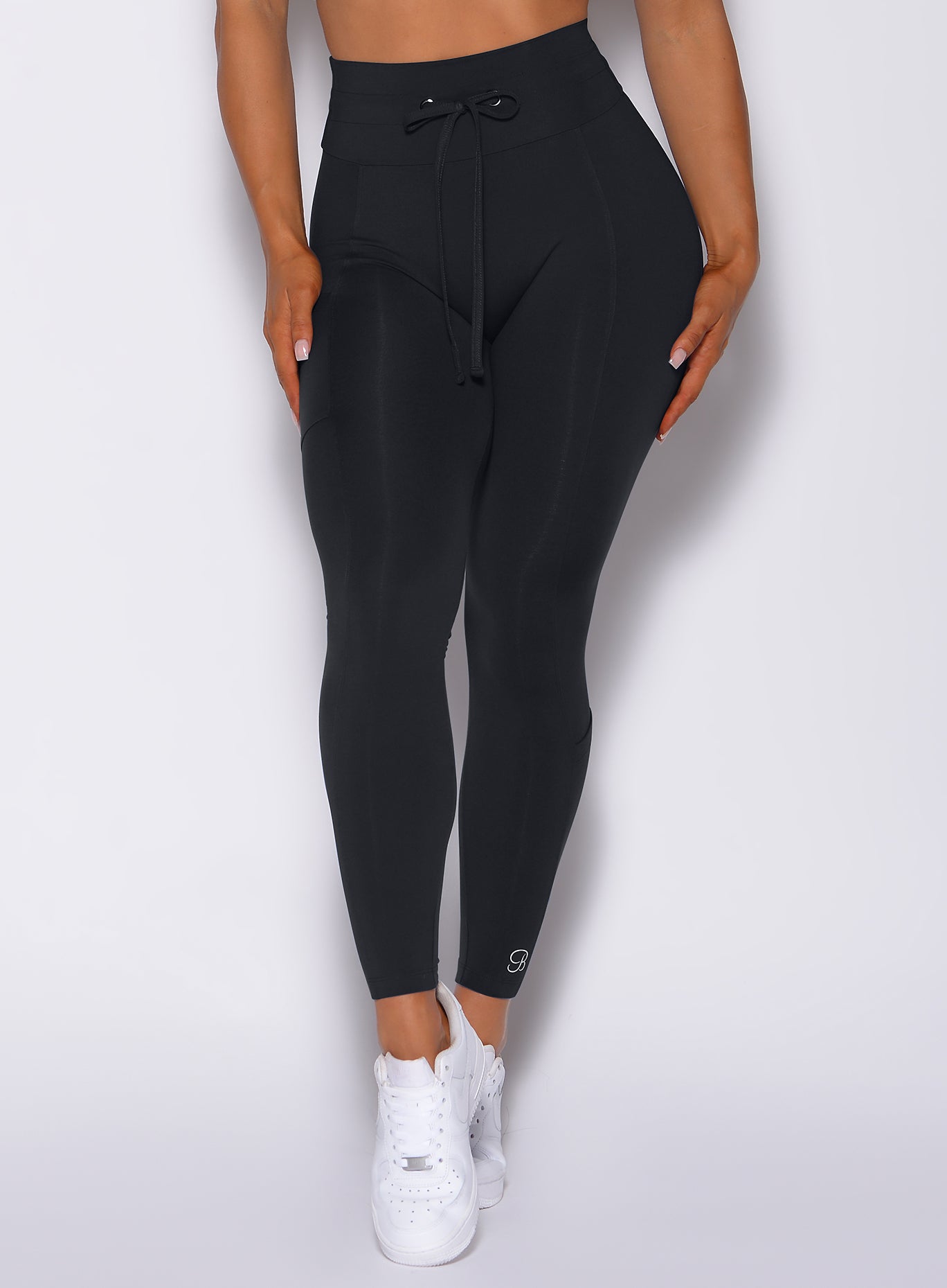 Zoomed front profile view of a model wearing our black empower leggings
