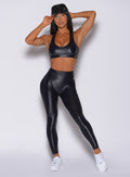 Front profile view of a model in our black gloss leggings and a matching bra