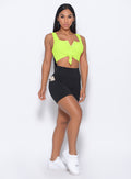 Front profile view of the model in our black pocket biker shorts and a neon yellow bra