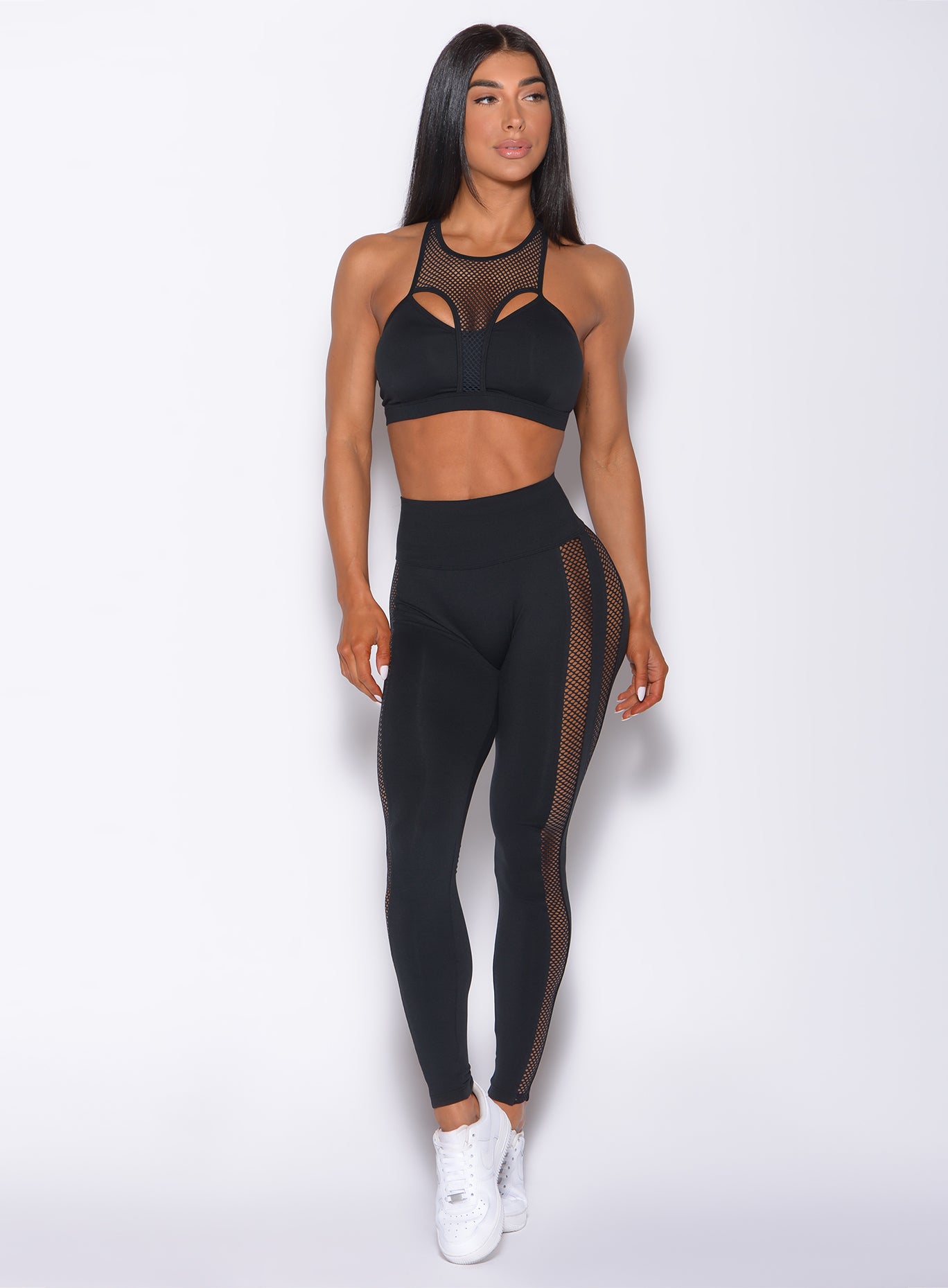 Front profile view of a model in our black Mohawk leggings and a matching sports bra