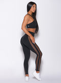 Right side profile view of a model wearing our black Mohawk leggings and a matching bra