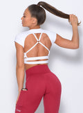 Back profile of the model in the white open back tee