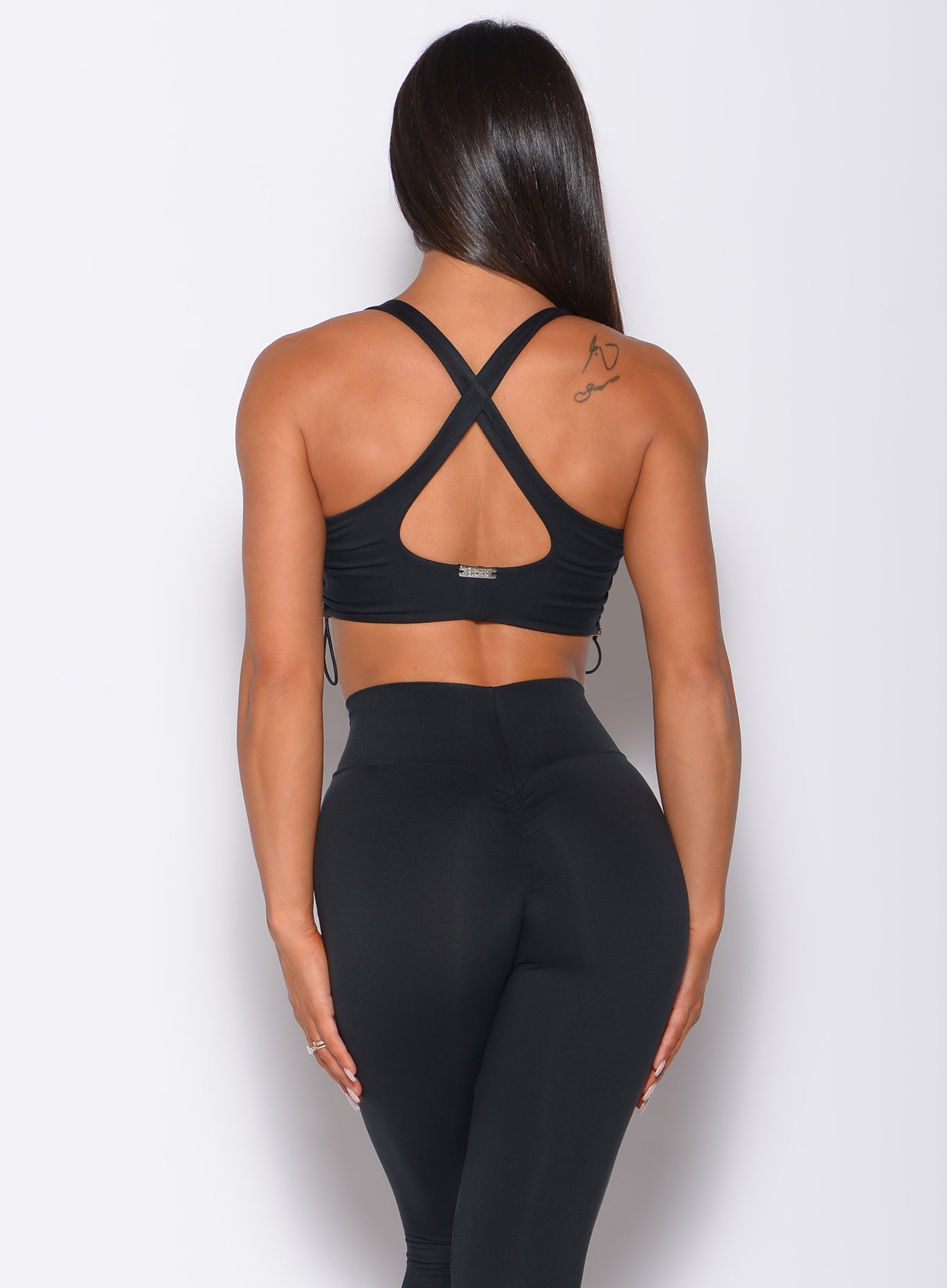 Black Toggle Sports Bra with adjustable side cinching and a strappy back for a custom gym fit.