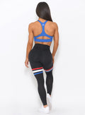 full back view of the model wearing our high waisted Scrunch Thigh high in black with three stripes on the thighs and a black sports bra