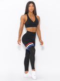 Model facing forward wearing our high waisted Scrunch Thigh high in black with three stripes on the thighs and a black sports bra