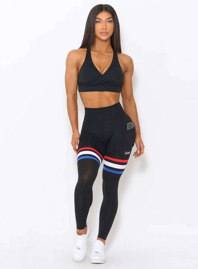 Front profile of the model wearing our Scrunch Thigh high in black with three stripes on the thighs and a black sports bra