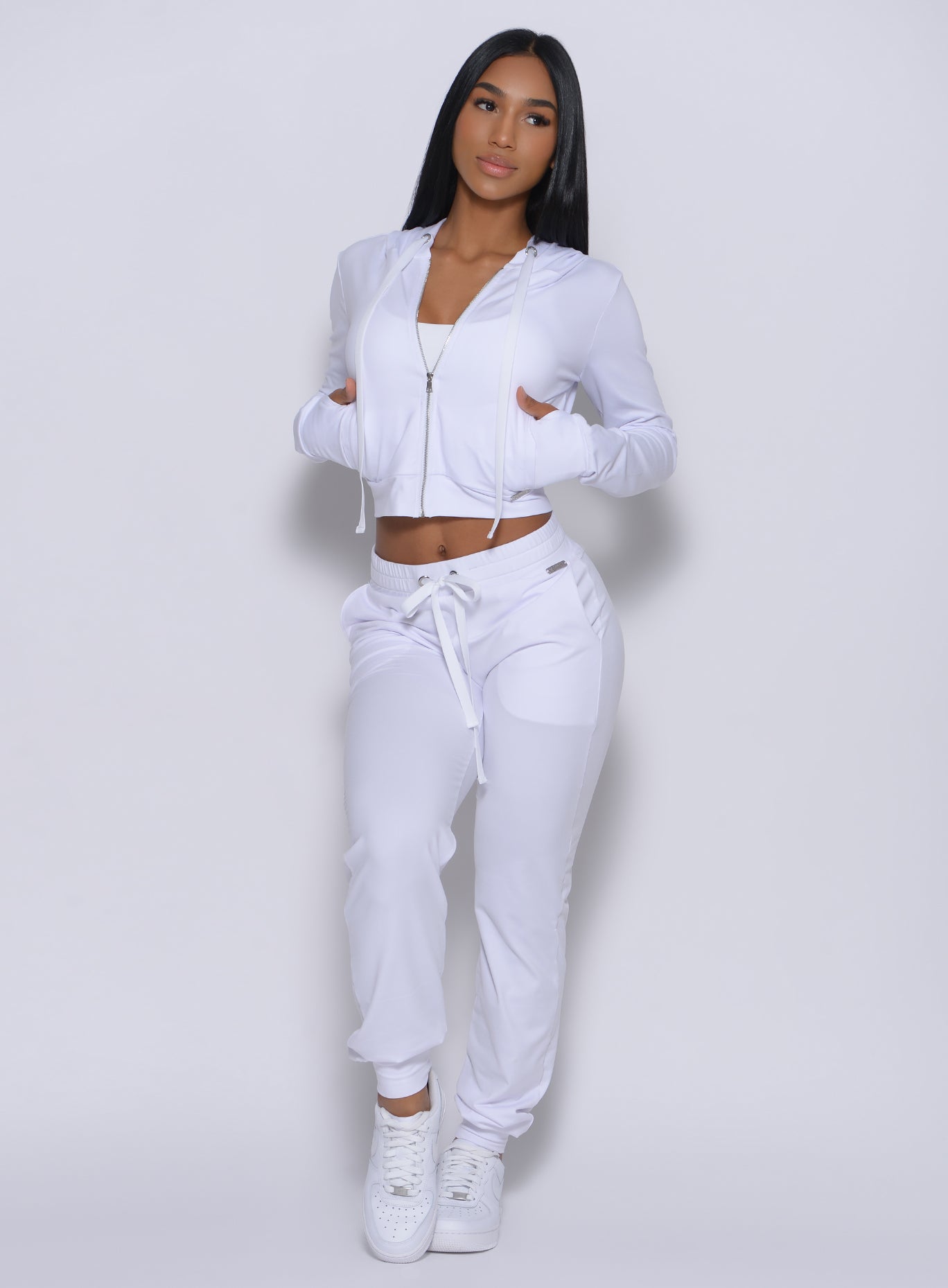 Front profile view of the model wearing our white signature jacket and a matching joggers