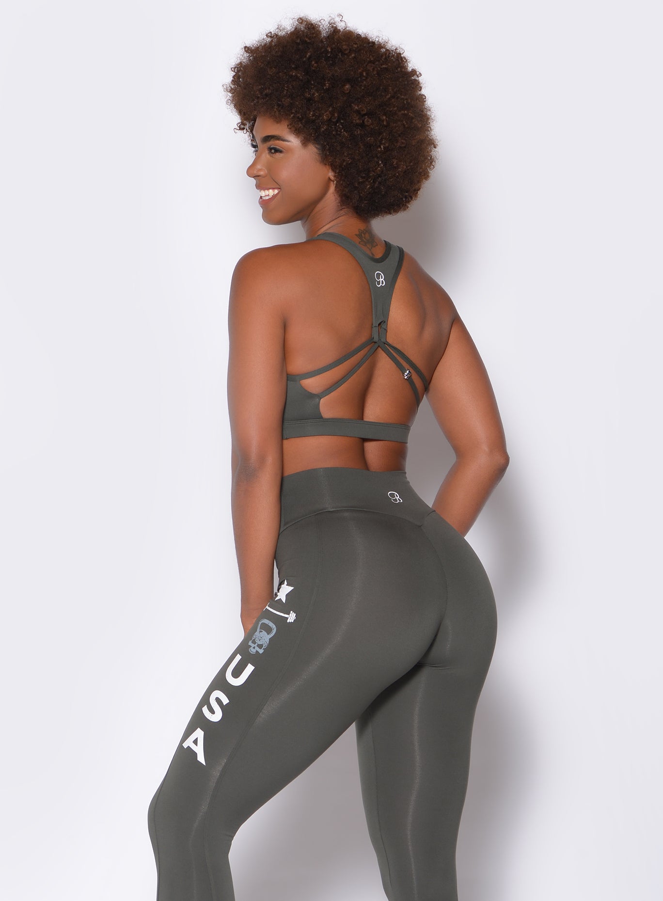 side view of model in our skull crusher sports bra in the color hunter green