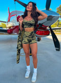 Front profile view of a model holding her hair wearing  our bright army camo straight up shorts and a matching bra