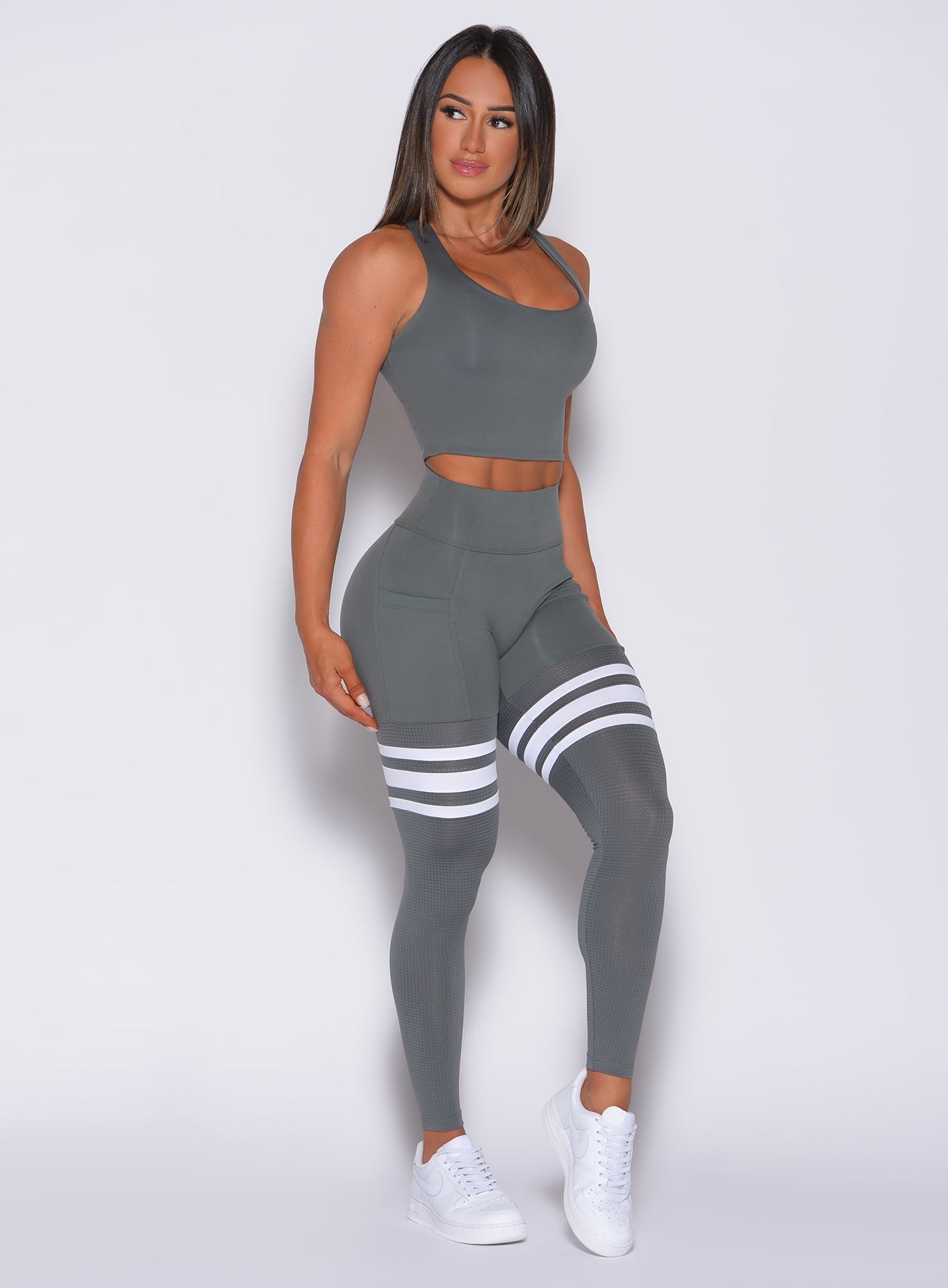 Right side profile view of a model angled right wearing our scrunch thigh high in steel gray color and a matching bra