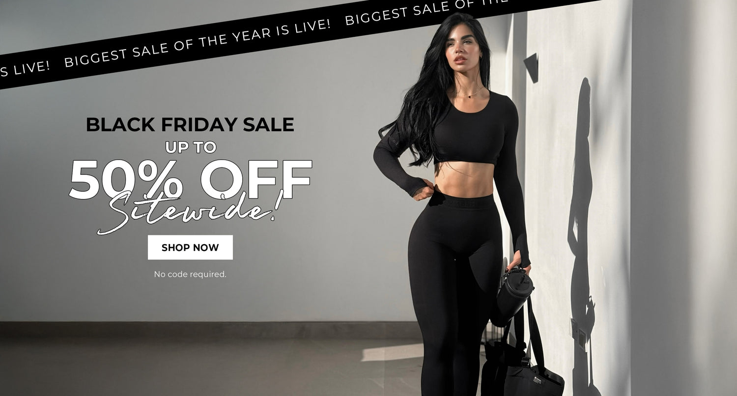Woman in black athletic wear standing against a gray wall with Black Friday sale text. Text reads BIGGEST SALE OF THE YEAR IS LIVE! BLACK FRIDAY SALE UP TO 50% OFF SITEWIDE NO CODE REQUIRED. SHOP NOW in a white box