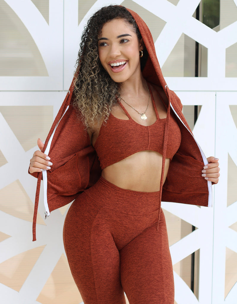 front view of female in a fall color hoodie, sports bra and activewear leggings 