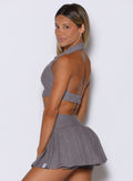 left side view of a model looking over her shoulder wearing the Ace Active Top in Champion Gray color 