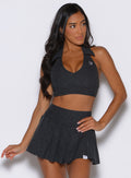 frontal view of a model wearing the Ace Active Top in Charcoal color paired with the matching champion skort