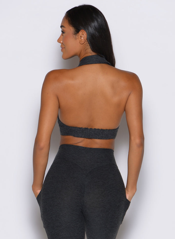 back side view of a model facing to the left side wearing the Ace Active Top in Charcoal color