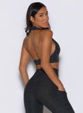 back right side view of a model looking over her shoulder wearing the Ace Active Top in Charcoal color