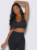 frontal view of a model with one hand resting on top of her head wearing the Ace Active Top in Charcoal color