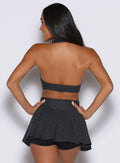 back side view of a model wearing the Ace Active Top in Charcoal color paired with the matching champion skort