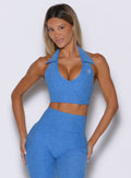 front view of a model with both hands resting on her thighs wearing the Ace Active Top in Legacy Blue color