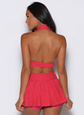 back profile shot of a model wearing the Ace Active Top in Victory Ruby color paired with the matching champion skort 