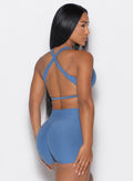 back profile of a model wearing the Ace Sports Bra and the matching shorts in Chambray color