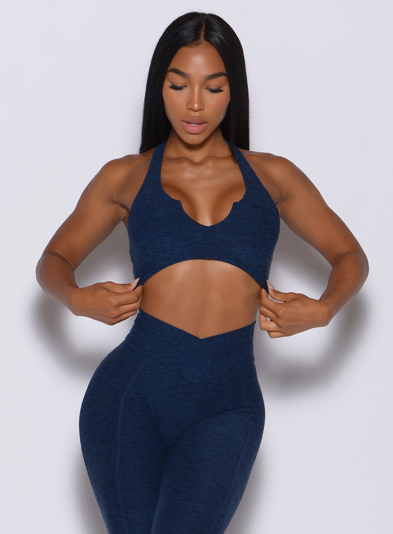 front profile view of a model in our ace sports bra in sapphire blue color and a matching leggings 