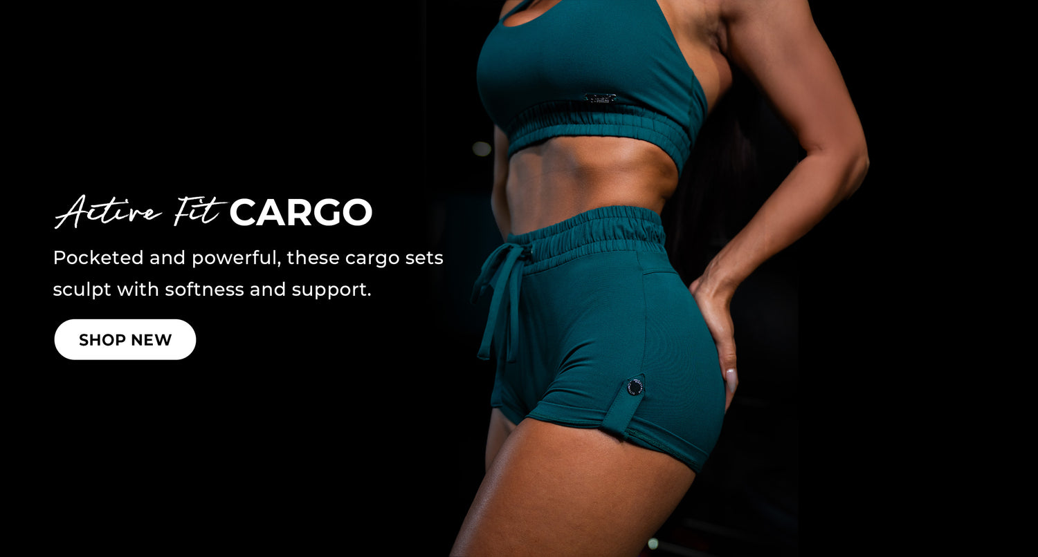 Image of a fit model wearing an active set. The set includes a jewel tone green halter sports bra and matching shorts with cargo pockets. White text reads: 'Active Fit Cargo. Pocketed and powerful, these cargo sets sculpt with softness and support.' CTA 'Shop New'