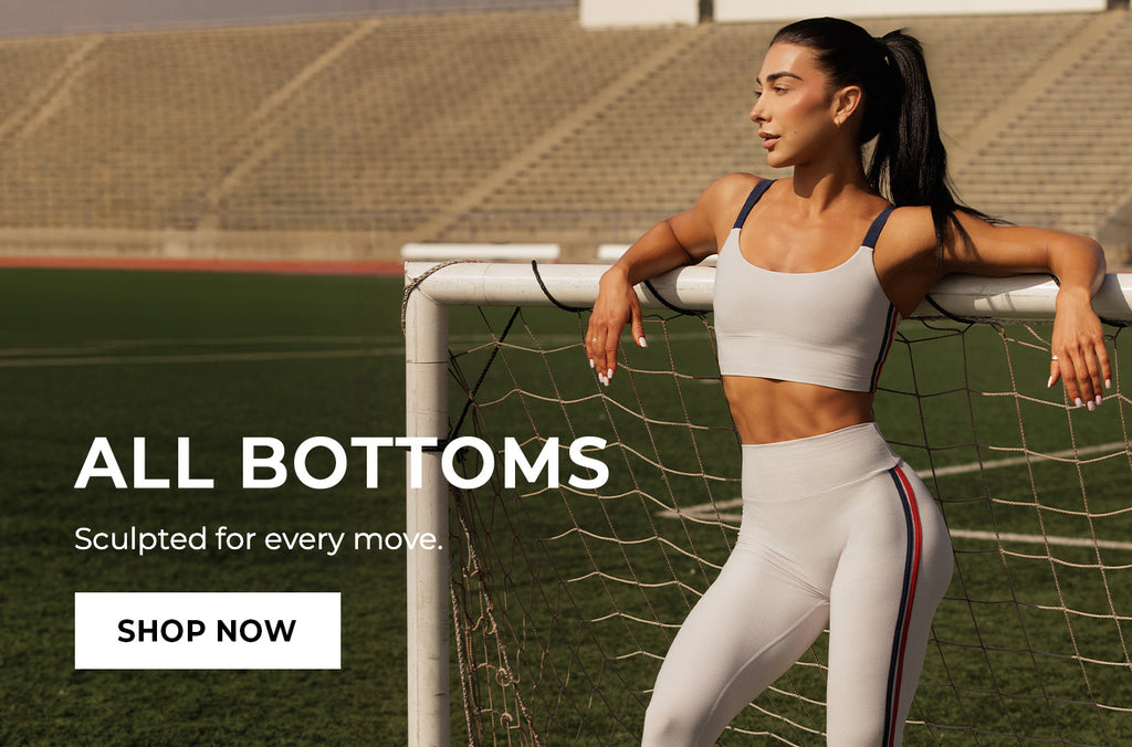 Woman in gray athletic wear leaning against a soccer goal with promotional text "ALL BOTTOMS Sculpted for every move." Call to action: SHOP NOW