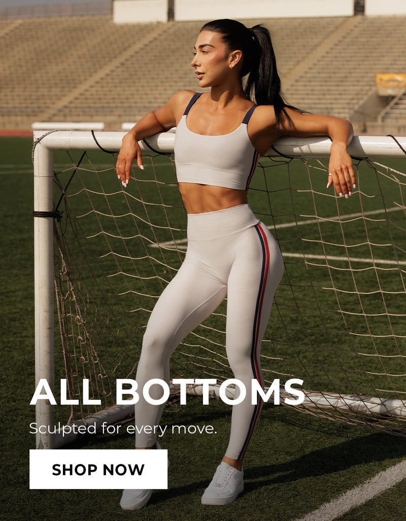 Woman in gray athletic wear leaning against a soccer goal with promotional text "ALL BOTTOMS Sculpted for every move." Call to action: SHOP NOW