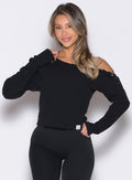 front profile view of a model with one hand on her waist wearing the Allure Pullover in Black color