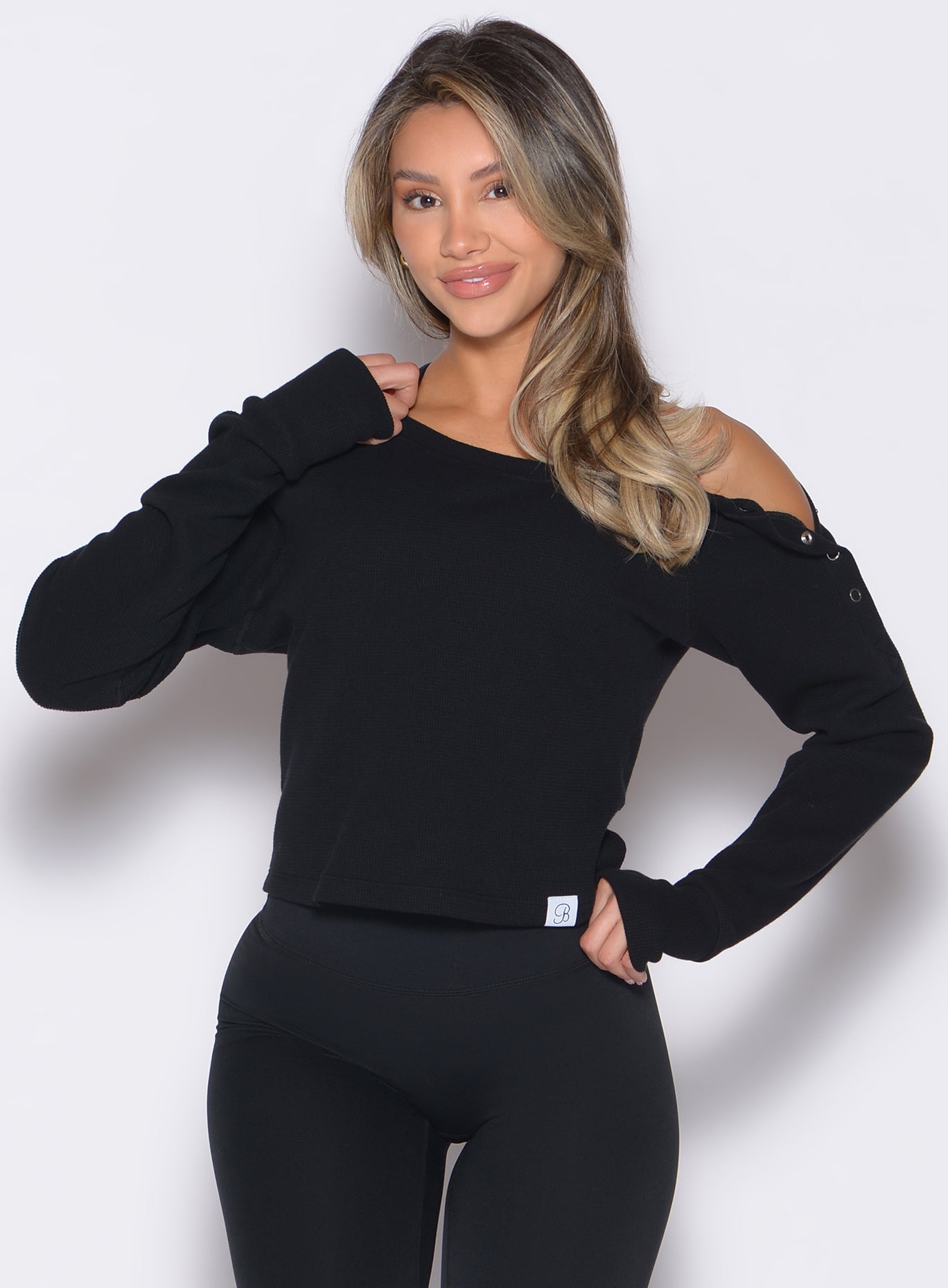Black Allure Pullover in waffle knit with snap shoulders and thumbholes for a cozy gym layer.