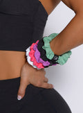 model with one hand on her waist with the B Scrunchie in purple rain color on her wrist