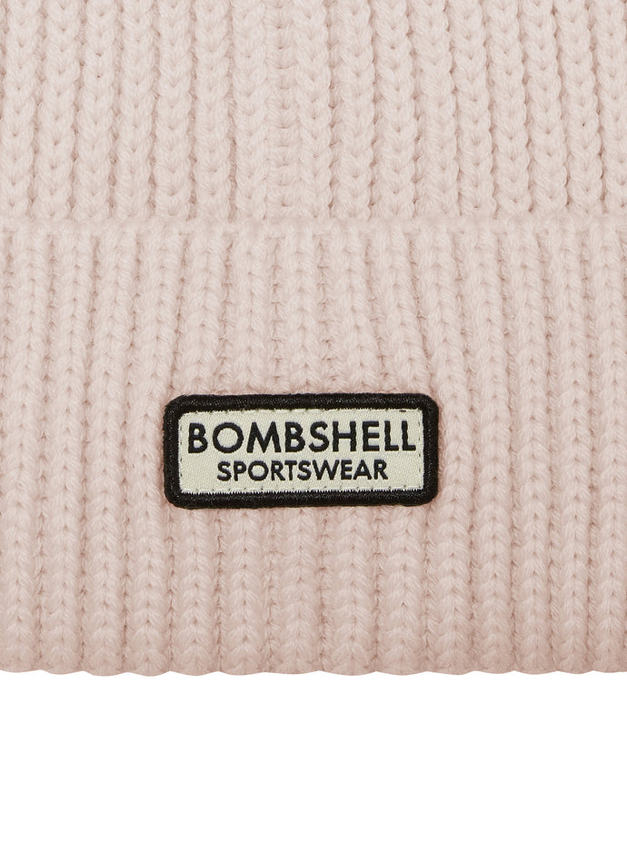 close up shot of the Bombshell Sportswear logo on the B Beanie in cream color