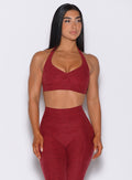 front profile view of a model wearing our Backless Bra in Garnet Red color and a matching leggings 