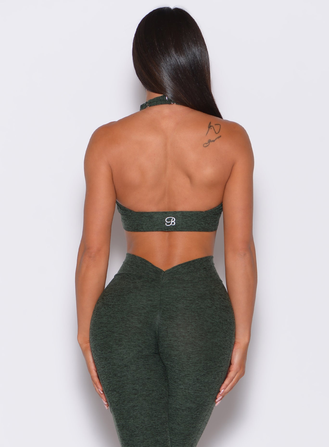back profile view of a model in our backless bra in hunter green and a matching leggings