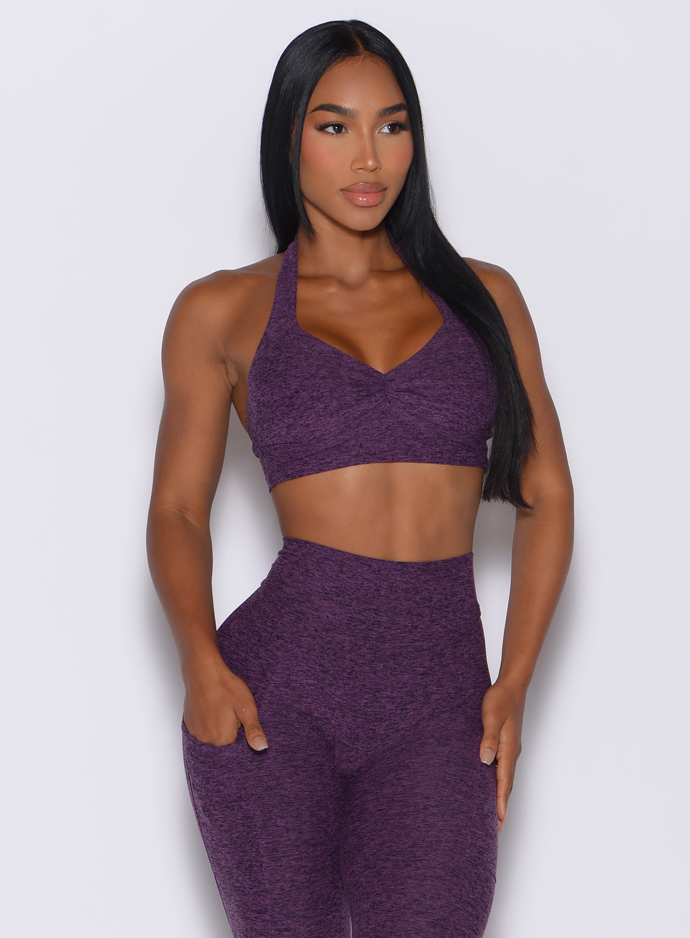 front  profile view of a model wearing our backless bra in Purple Passion color along with the matching leggings 