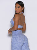 Left side profile view of the model looking over her shoulder wearing the Backless Bra in Leopard Baby Lavender.
