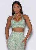 Front profile view of the model wearing our Backless Bra in Leopard Cool Matcha paired with matching leggings.
