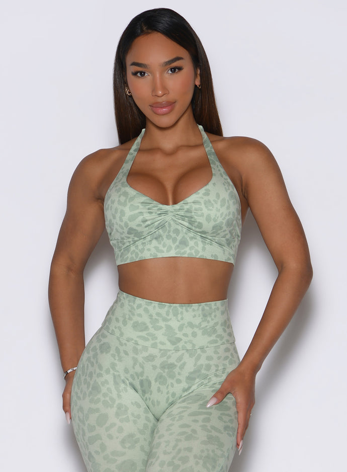 Front profile view of the model wearing our Backless Bra in Leopard Cool Matcha paired with matching leggings.