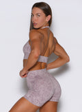 Left side profile view of the model wearing the Backless Bra in Leopard Violet Ice.
