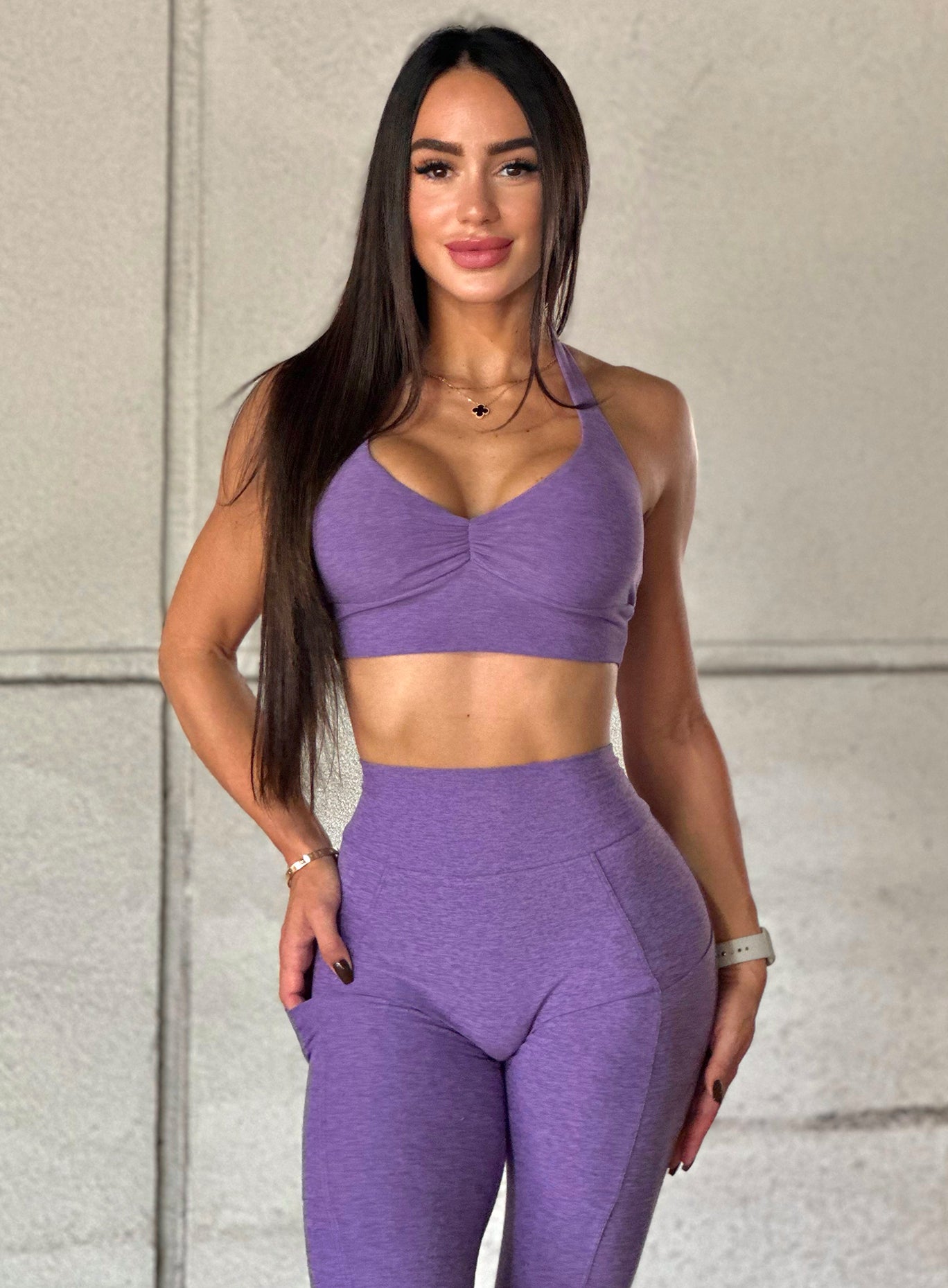front profile view of a mode facing forward l wearing our backless bra in violet color along with the matching leggings
