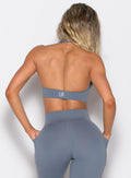 back profile view of a model wearing the Backless Knot Bra in Basalt color paired with the matching leggings 
