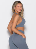 right side profile view of a model looking over her shoulder wearing the Backless Knot Bra in Basalt color