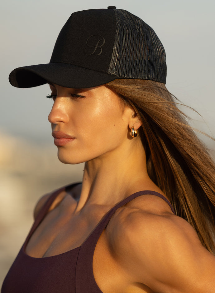 Left side view of the black B Active Hat, a lightweight and breathable performance gym trucker cap.