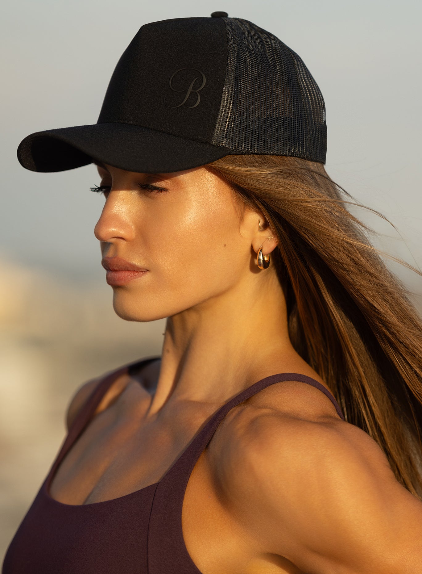 Left side view of the black B Active Hat, a lightweight and breathable performance gym trucker cap.