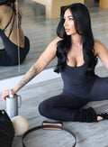 model sitting in indoors wearing the Form Bodysuit in Heathered Black color