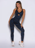 front profile view of a model wearing the Bombshell Bodysuit in Blue/Black camo color