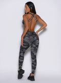 back profile view of a model facing to the left side wearing the Bombshell Bodysuit in Gray/Black camo color