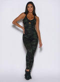 front profile view of a model with one hand on her waist wearing the Bombshell Bodysuit in Green/Black camo color