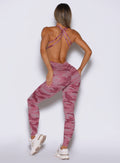 back profile view of a model wearing the Bombshell Bodysuit in Hibiscus camo color